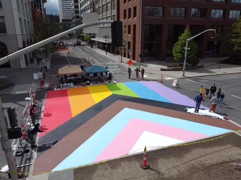 Progress Pride Flag painted onto a crosswalk in Spokane, huge and glorious.